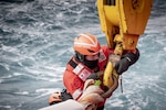 U.S. Coast Guard Petty Officer 3rd Class Caleb Garrett disconnects a crane hook from a small boat Jan. 22, 2020, near McMurdo Station, Antarctica.