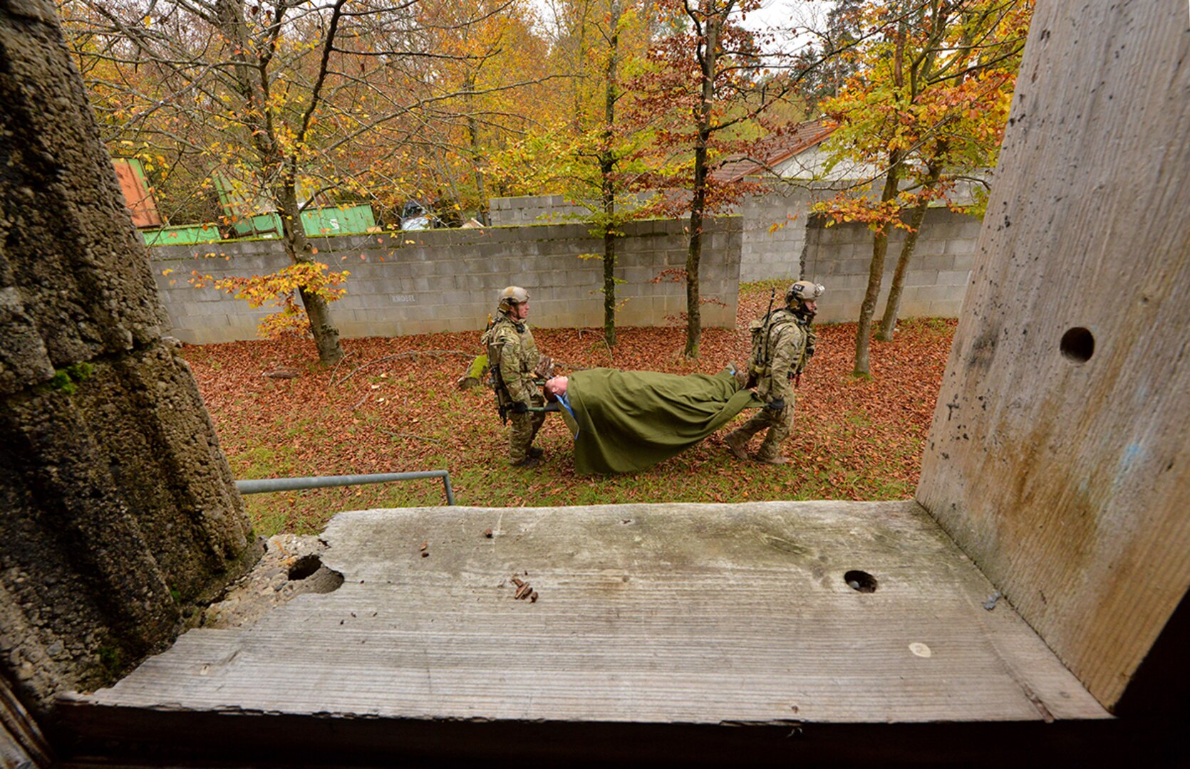 Two soldiers carry a mock wounded soldier on a litter.