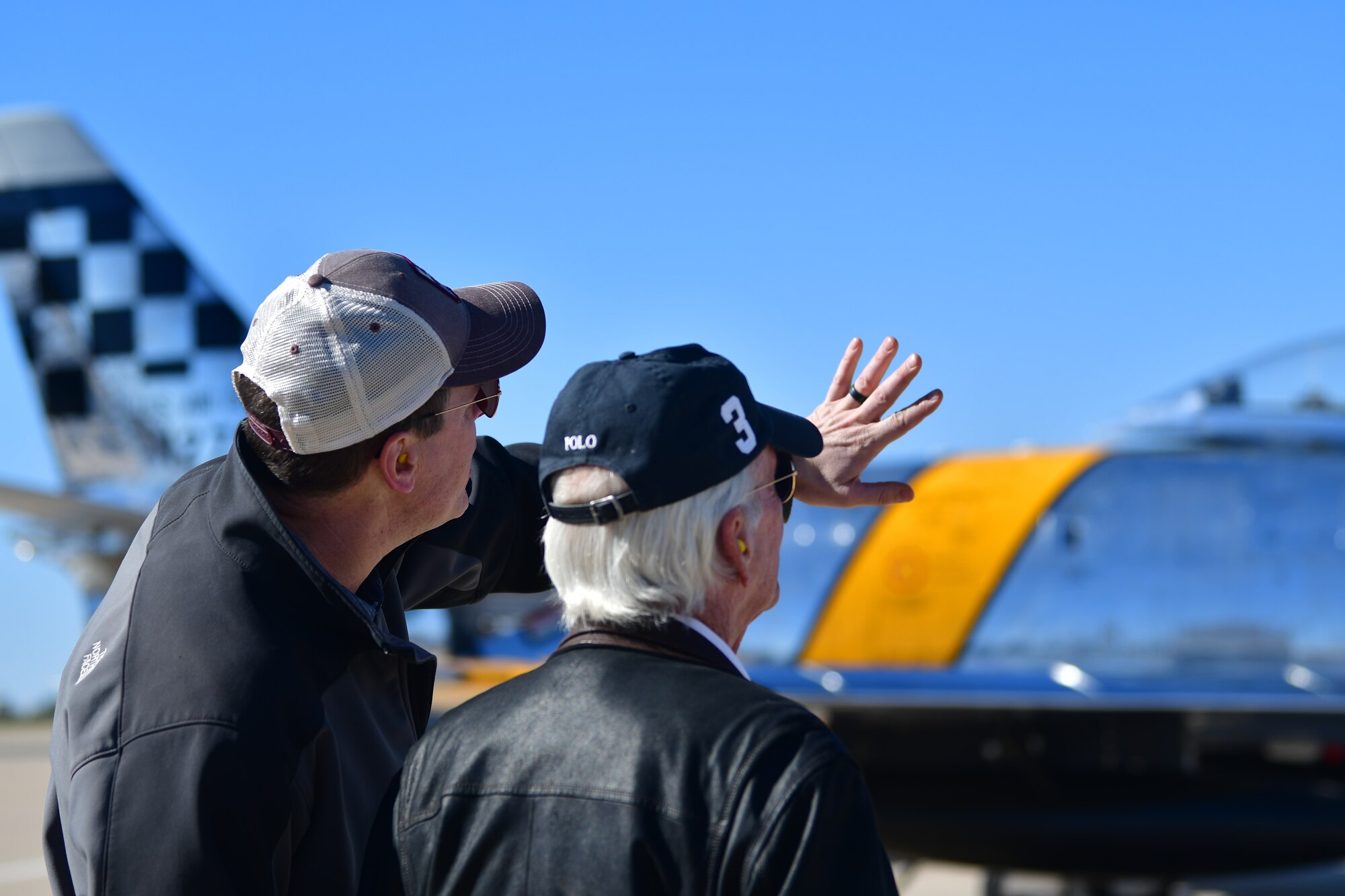Two men look at a plane.