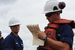 Coast Guard inspectors wearing safety equipment during an inspection