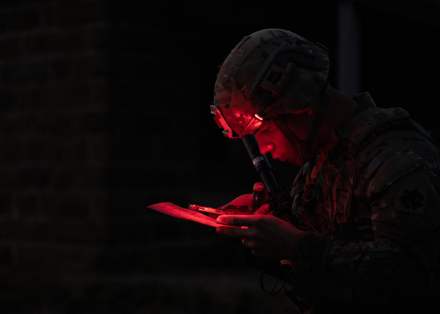 Oklahoma Army National Guard Soldier plots points on a map during the night land navigation challenge of the Best Warrior Competition at Camp Gruber Training Center, Oklahoma, March 4, 2022. (Oklahoma National Guard photo by Spc. Danielle Rayon)