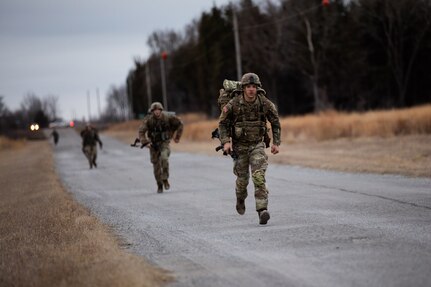Oklahoma Army National Guard Soldier Spc. David Jeffrey, from San Jose, Costa Rica, and a member of 1st Squadron, 180th Calvary Regiment, 45th Infantry Brigade Combat Team, crosses the finish line of the 12-mile ruck march during the Best Warrior Competition at Camp Gruber Training Center, Oklahoma, March 6, 2022. (Oklahoma National Guard photo by Spc. Danielle Rayon)