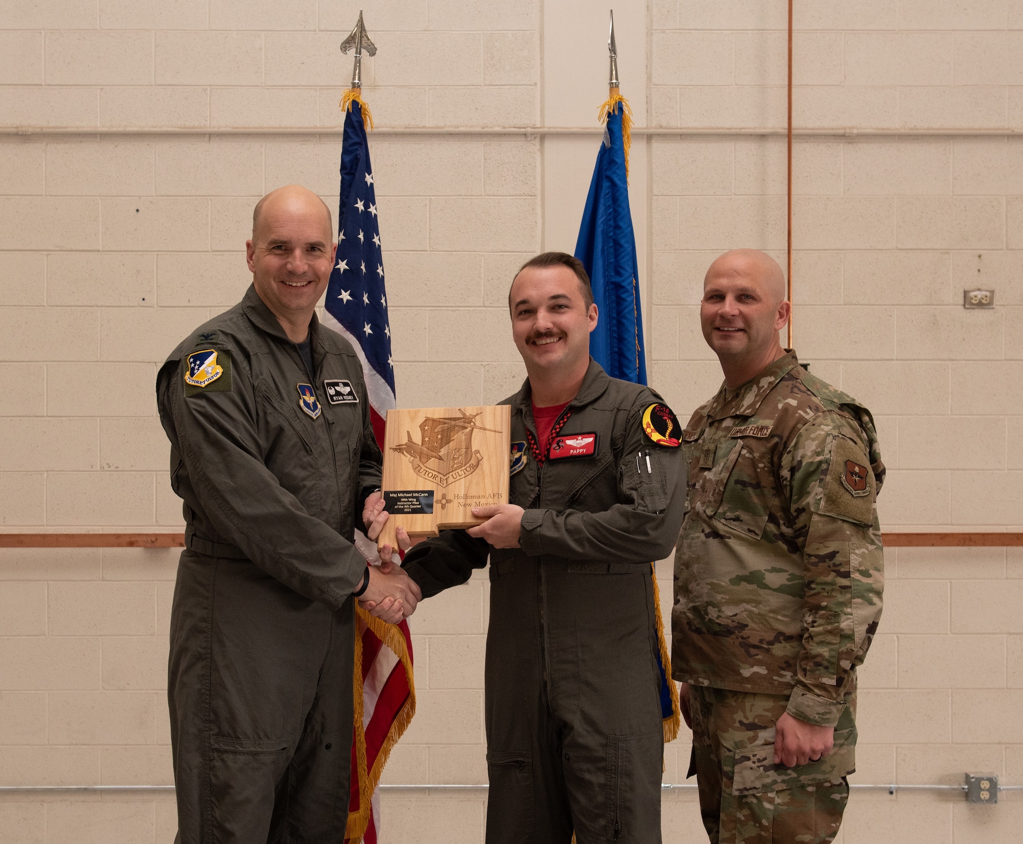 Maj. Michael McCann, 54th Fighter Group quarterly award winner, accepts the 49th Wing Instructor Pilot award during the 49th Wing’s 4th quarter award ceremony, March 4, 2022, on Holloman Air Force Base, New Mexico. Quarterly award winners were selected based on their technical expertise, demonstration of leadership and job performance. (U.S. Air Force photo by Airman 1st Class Nicholas Paczkowski)