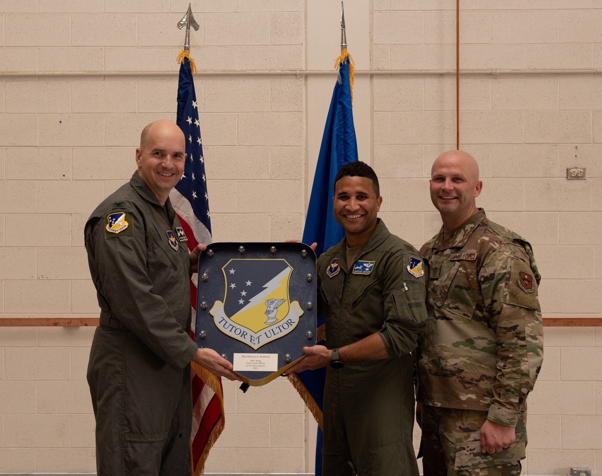 Maj. Marcus Anthony, 49th Operations Group annual award winner, accepts the 49th Wing Field Grade Officer of the year award during the 49th Wing annual awards ceremony, March 4, 2022, on Holloman Air Force Base, New Mexico. Annual award winners were selected based on their technical expertise, demonstration of leadership and job performance. (U.S. Air Force photo by Airman 1st Class Nicholas Paczkowski)