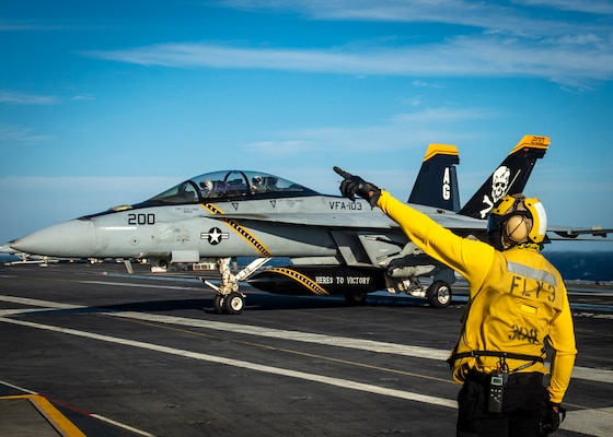 Aviation Boatswain's Mate (handling) 1st Class Basir Riddick, signals an F/A-18F Super Hornet aircraft, attached to Strike Fighter Squadron (VFA) 103, on the flight deck of the aircraft carrier USS George H.W. Bush (CVN 77) during Tailored Ship's Training Availability/Final Evaluation Problem (TSTA/FEP)