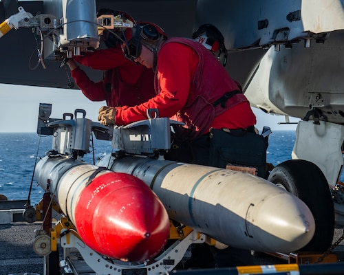 Sailors assigned to Strike Fighter Squadron (VFA) 86, attach ordinance onto an F/A-18F Super Hornet aircraft on the flight deck of the aircraft carrier USS George H.W. Bush (CVN 77) during Tailored Ship's Training Availability/Final Evaluation Problem (TSTA/FEP)