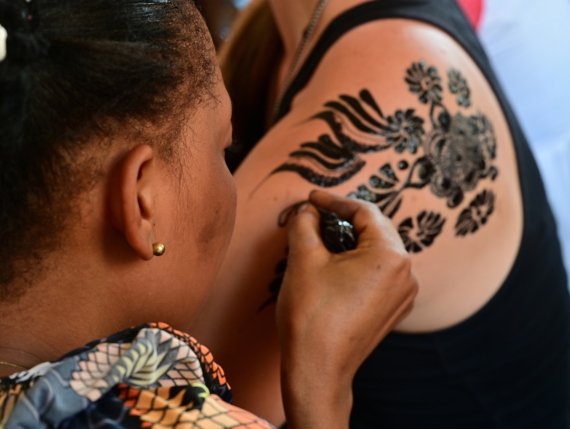 A member of the Air Base 201 Women’s Association receives a henna tattoo from a member of the Tedhilt Women’s Association in Agadez, Niger, March 6, 2022. The AB201 Women’s Association and Tedhilt Women’s Association held a panel discussion during an International Women’s Day celebration. The event provided the women the opportunity to discuss their perspectives on leadership and female empowerment. The AB201 Women’s Association supported the Tedhilt Women’s Association by purchasing approximately 250,000 West African CFA francs ($420 USD) of handmade scarfs, ceramic sculptures, received henna tattoos and commissioned four dresses. (U.S. Air Force photo by Tech. Sgt. Stephanie Longoria)