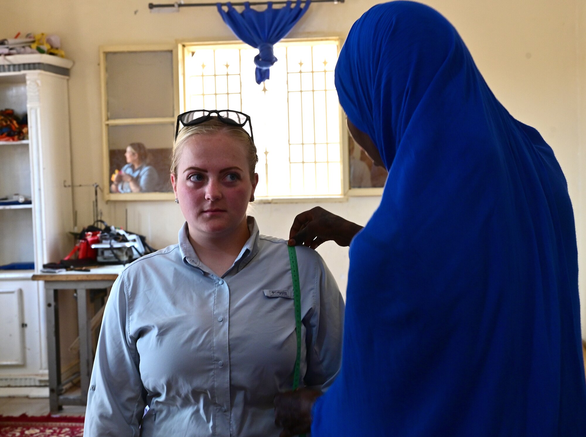 Airman 1st Class Brielee Lucero, Air Base 201 Women’s Association member, is fitted for a dress by a member of the Tedhilt Women’s Association during an International Women’s Day celebration in Agadez, Niger, March 6, 2022. Tedhilt Women’s Association offers a two-year program, which teaches women how to use a sewing machine and build a business to become financially secure. AB 201 Women’s Association supported the Tedhilt Women’s Association by purchasing approximately 250,000 West African CFA francs ($420 USD) of handmade scarfs, ceramic sculptures, received henna tattoos and commissioned four dresses. (U.S. Air Force photo by Tech. Sgt. Stephanie Longoria)