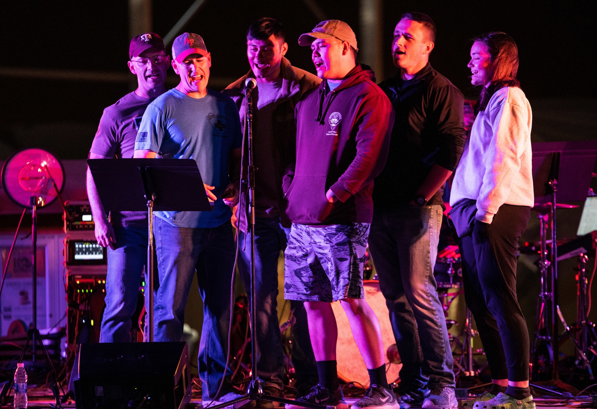 Service members from the 378th Air Expeditionary Wing perform live band karaoke during a U.S. Air Forces Central Band concert at Prince Sultan Air Base, Kingdom of Saudi Arabia, Feb. 27, 2022. The AFCENT Band supports the morale of deployed troops by playing various concerts around the region. (U.S. Air Force photo by Senior Airman Jacob B. Wrightsman)