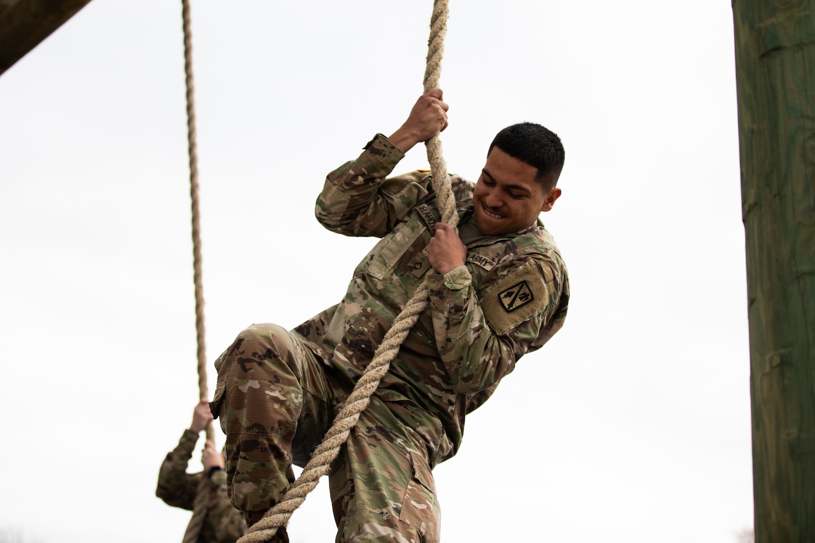 Pfc. Mario Delahoya, a member of 45th Field Artillery Brigade, Oklahoma Army National Guard, climbs a rope during the obstacle course event of the Best Warrior Competition at Camp Gruber Training Center, Oklahoma, March 5, 2022. The annual three-day event brought together Soldiers to test their proficiency in a variety of warrior tasks and drills.