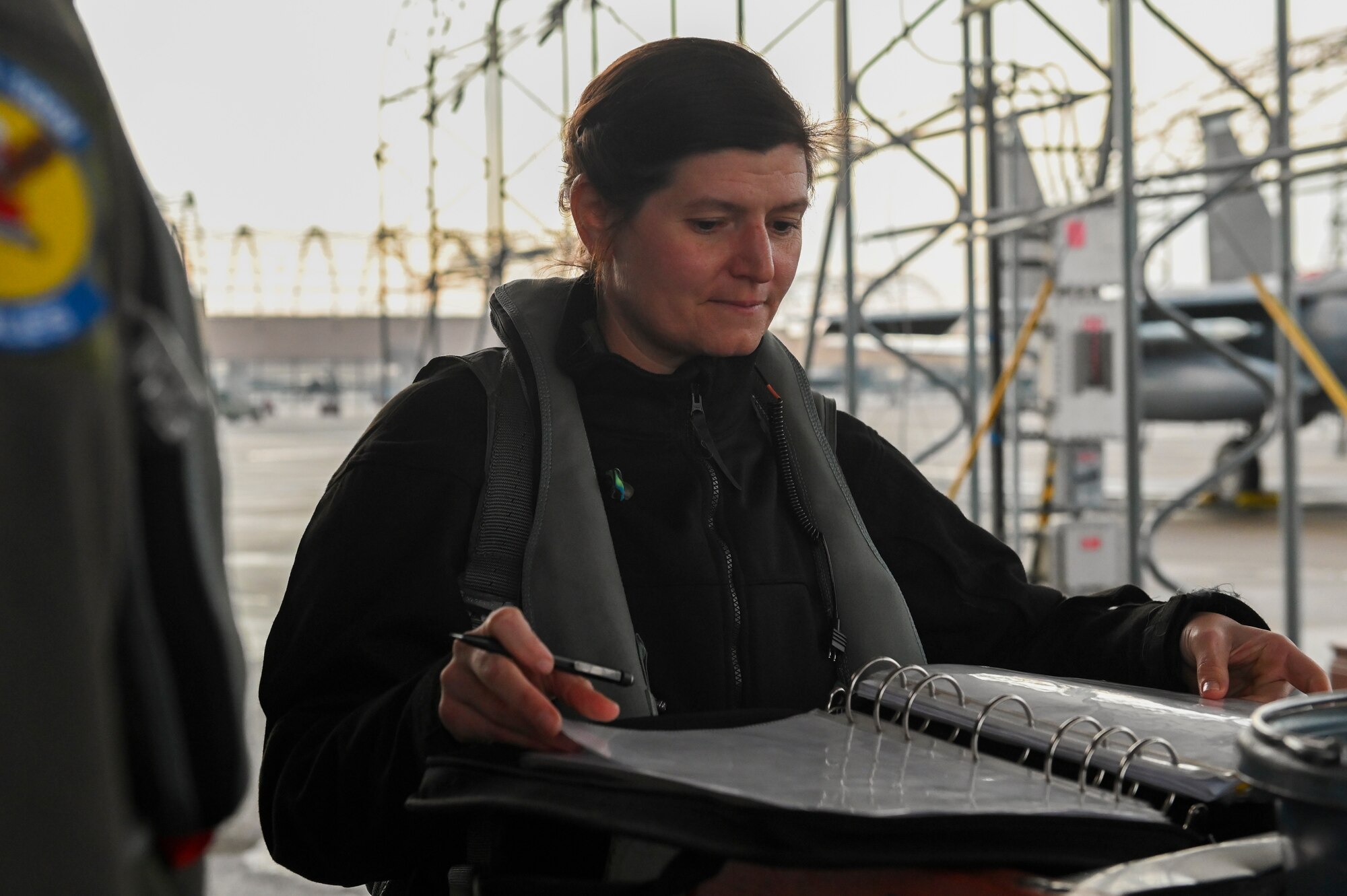 Lt. Col. Bridgett “Atlas” Fitzsimmons, 334th Fighter Squadron director of operations, inspects an aircraft log before a flight at Seymour Johnson Air Force Base, North Carolina, Jan. 5, 2022.