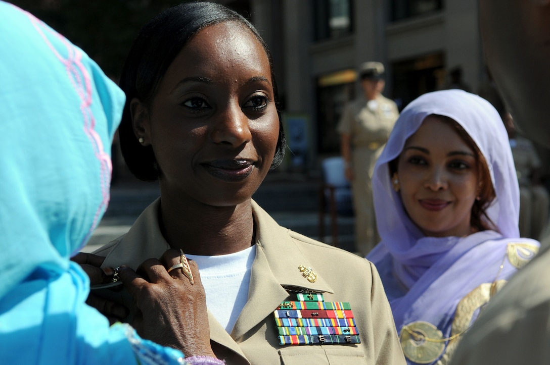 A sailor smiles during a ceremony.