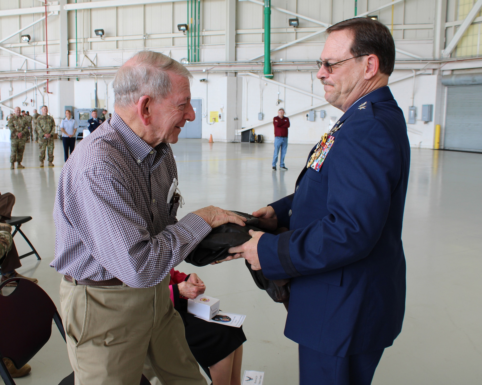 Lt. Gen. (retired) Billy M. Nabors, former Assistant Adjutant General (Air) and  Mississippi Air National Guard Commander, presents his father, Billy Nabors, with his flight jacket during his retirement ceremony, March 6, 2022, at Key Field Air  National Guard Base, Meridian, Mississippi.
