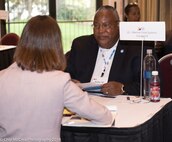 AJ Johnson sits at a table with a conference participant.