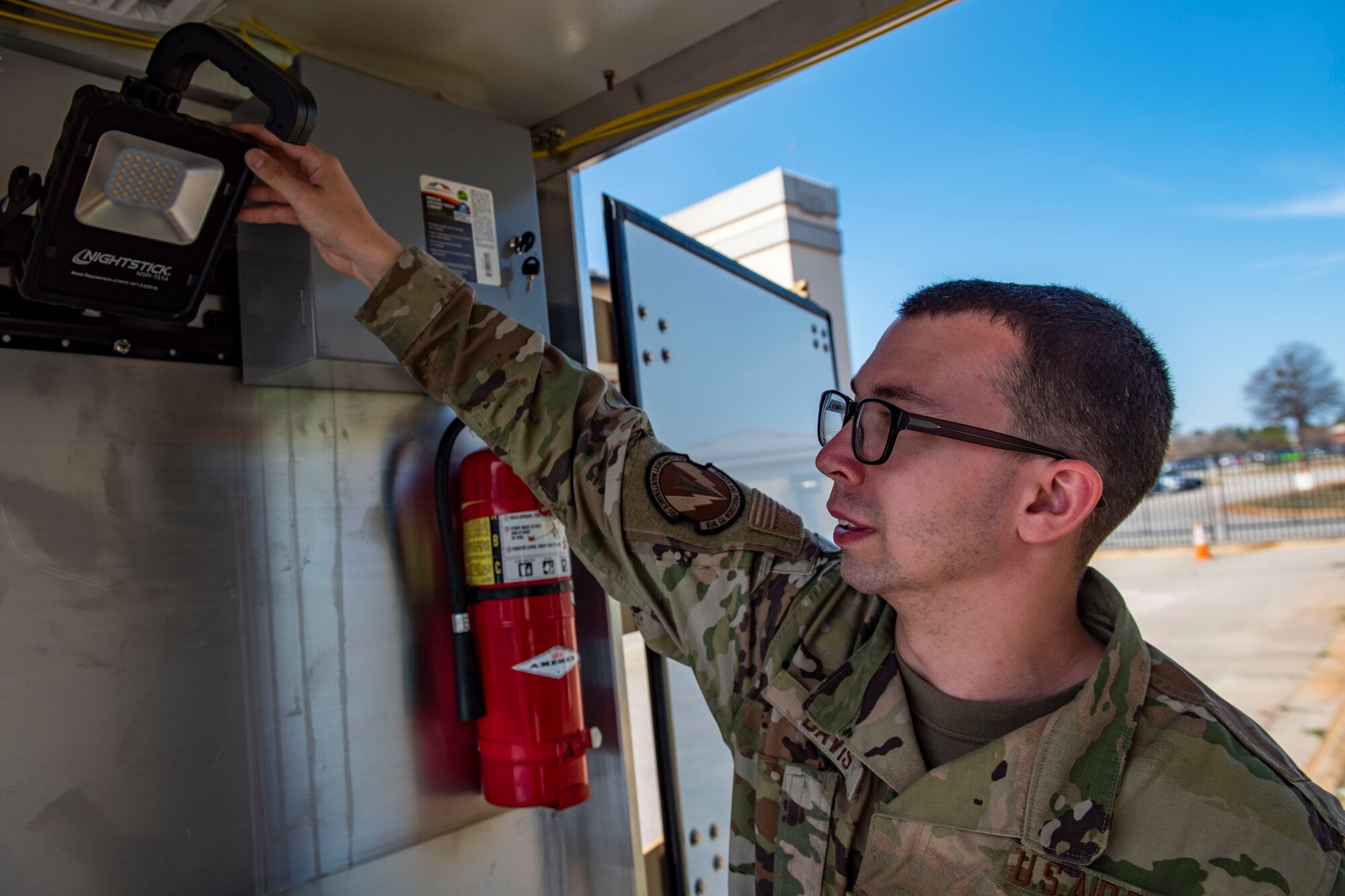 An Airman demonstrates one of the features of the mobile egress shop.