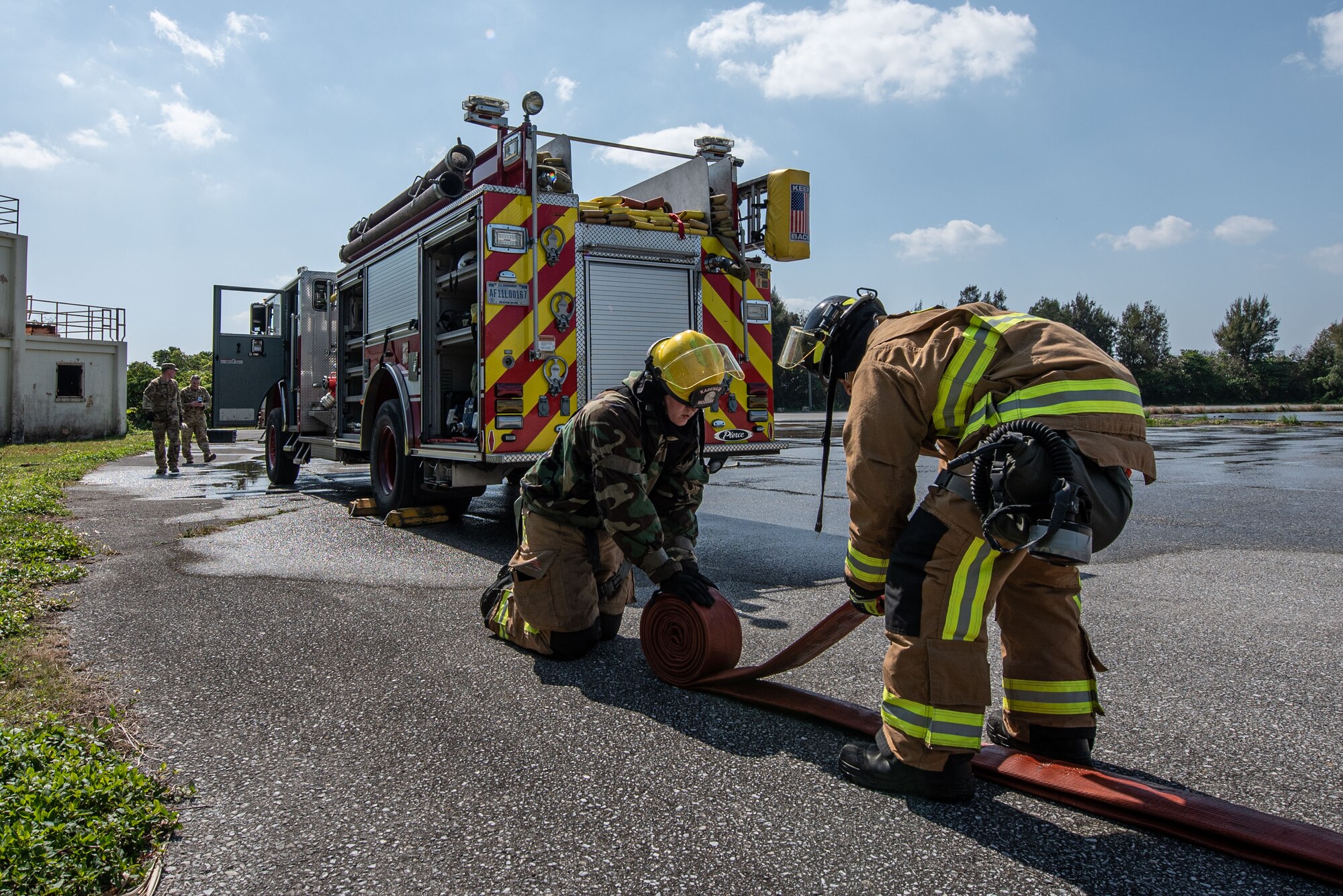 Firefighters roll a hose.