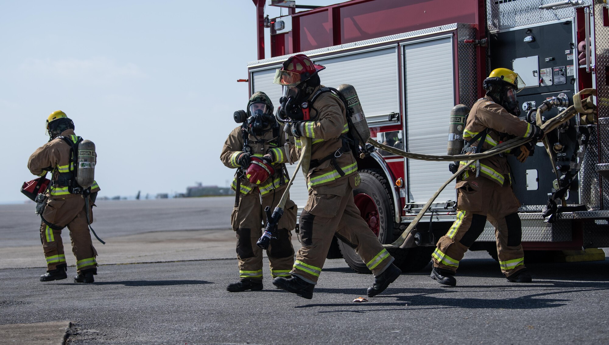 Firefighters prepare a hose.