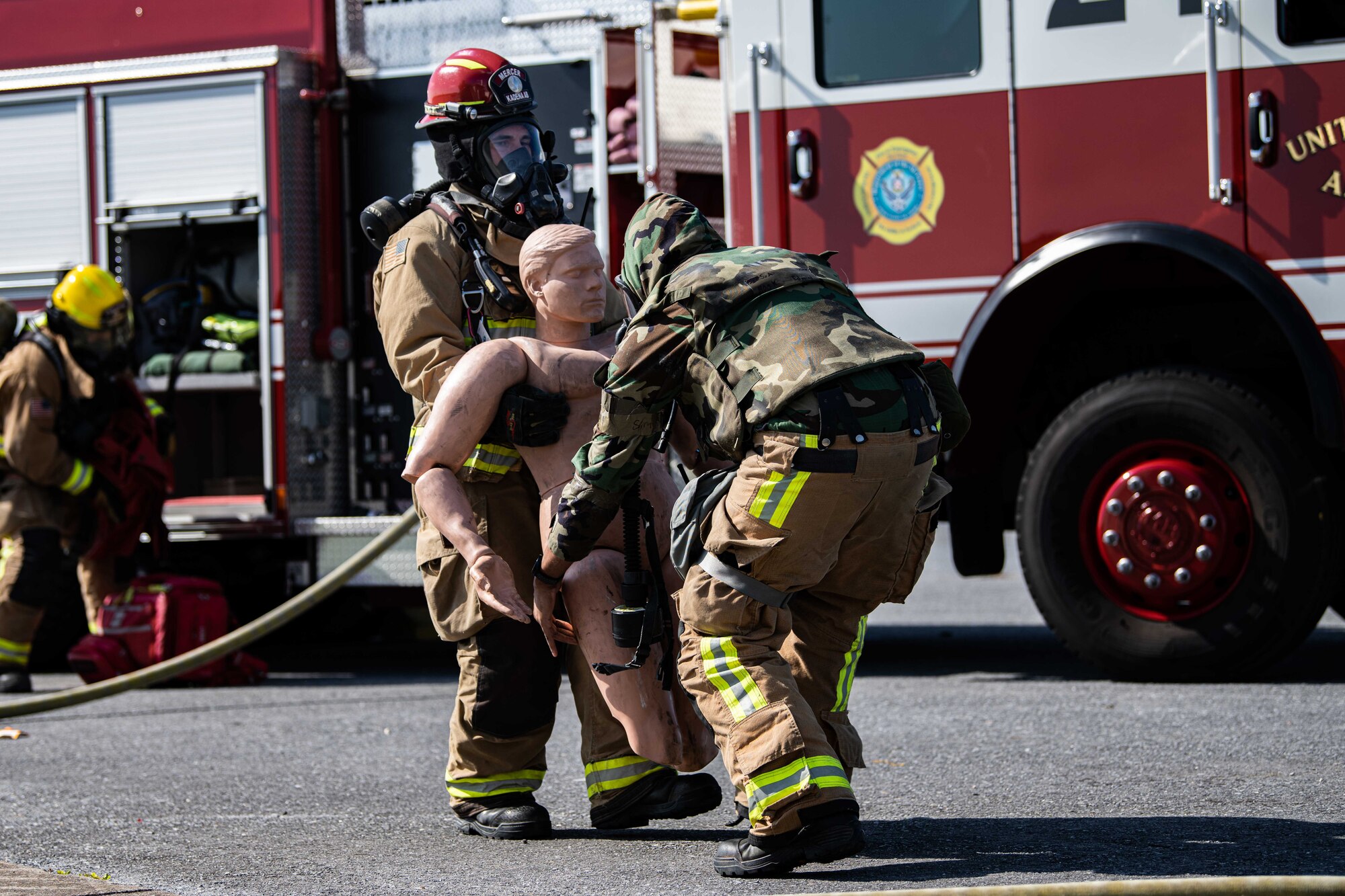 Firefighters help fake patient.