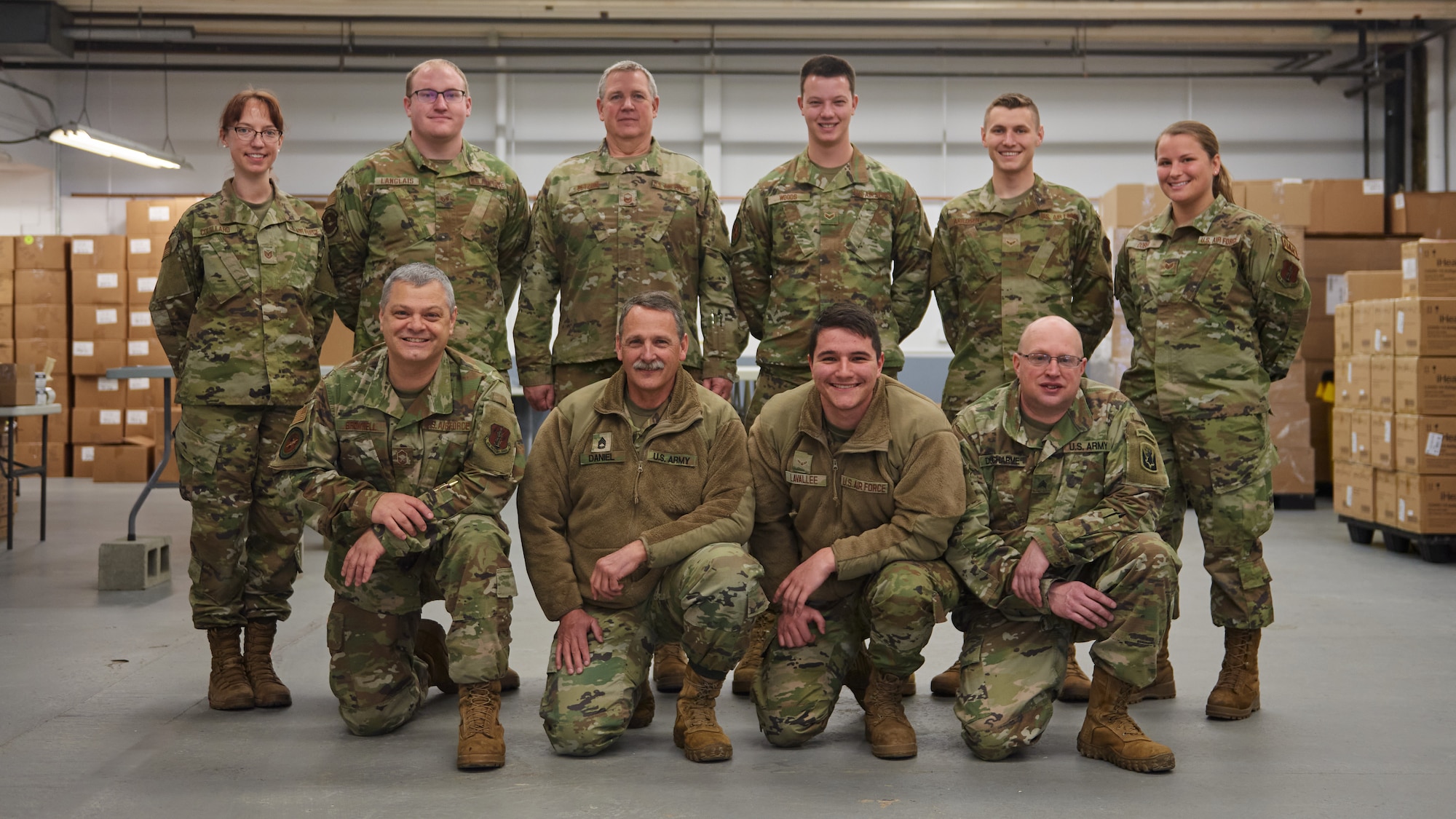 Photo of Airmen and Soldiers from the Vermont National Guard pose for a photo at a distribution center in Vermont, Feb. 8, 2022.