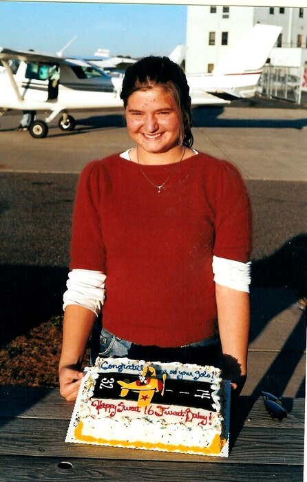 Lt. Col. Bridgett “Atlas” Fitzsimmons, 334th Fighter Squadron director of operations, poses with a cake on her 16th birthday at the Crystal Airport in Minnesota.