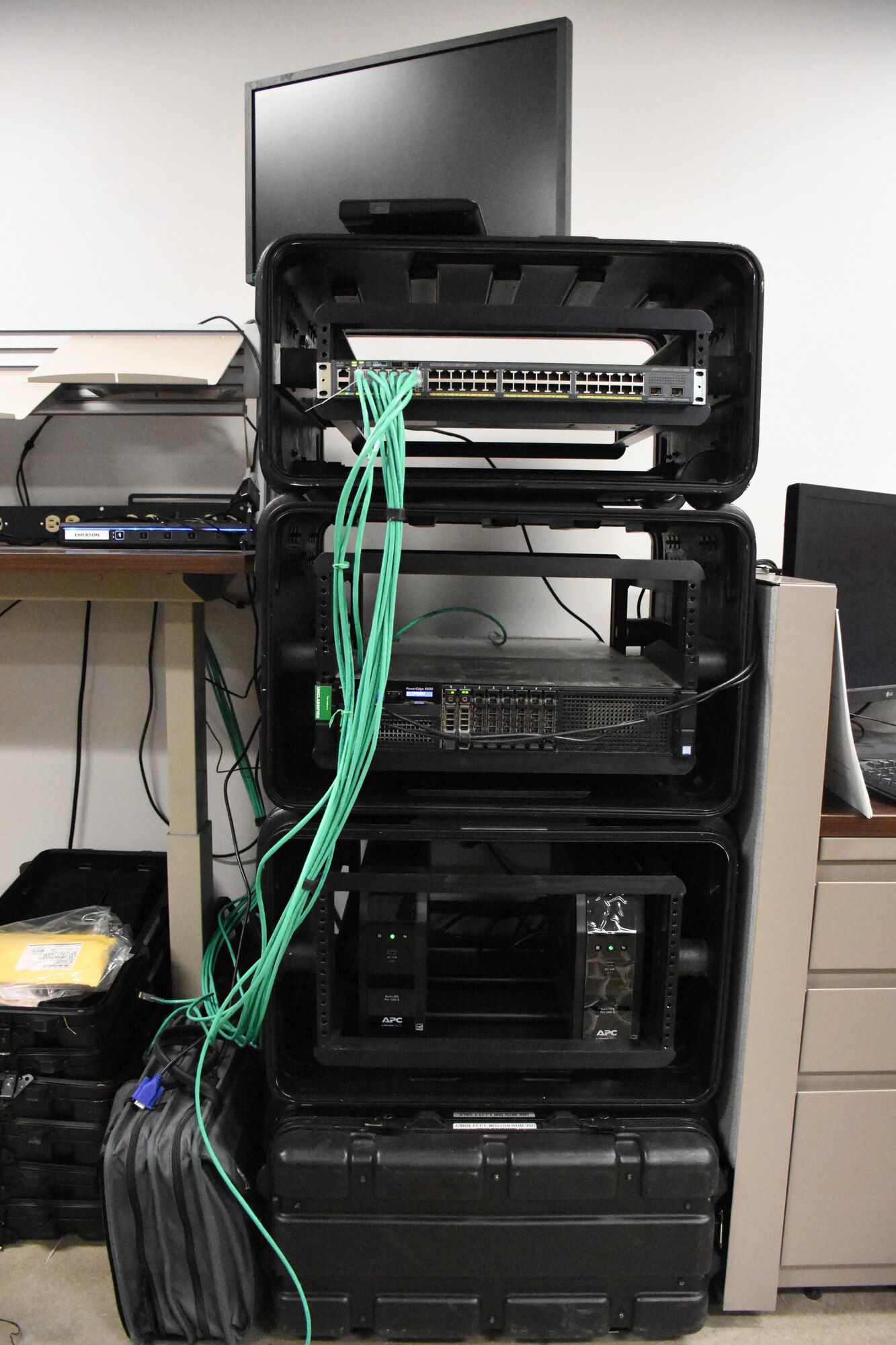 A black computer tower with a bundle of green wires