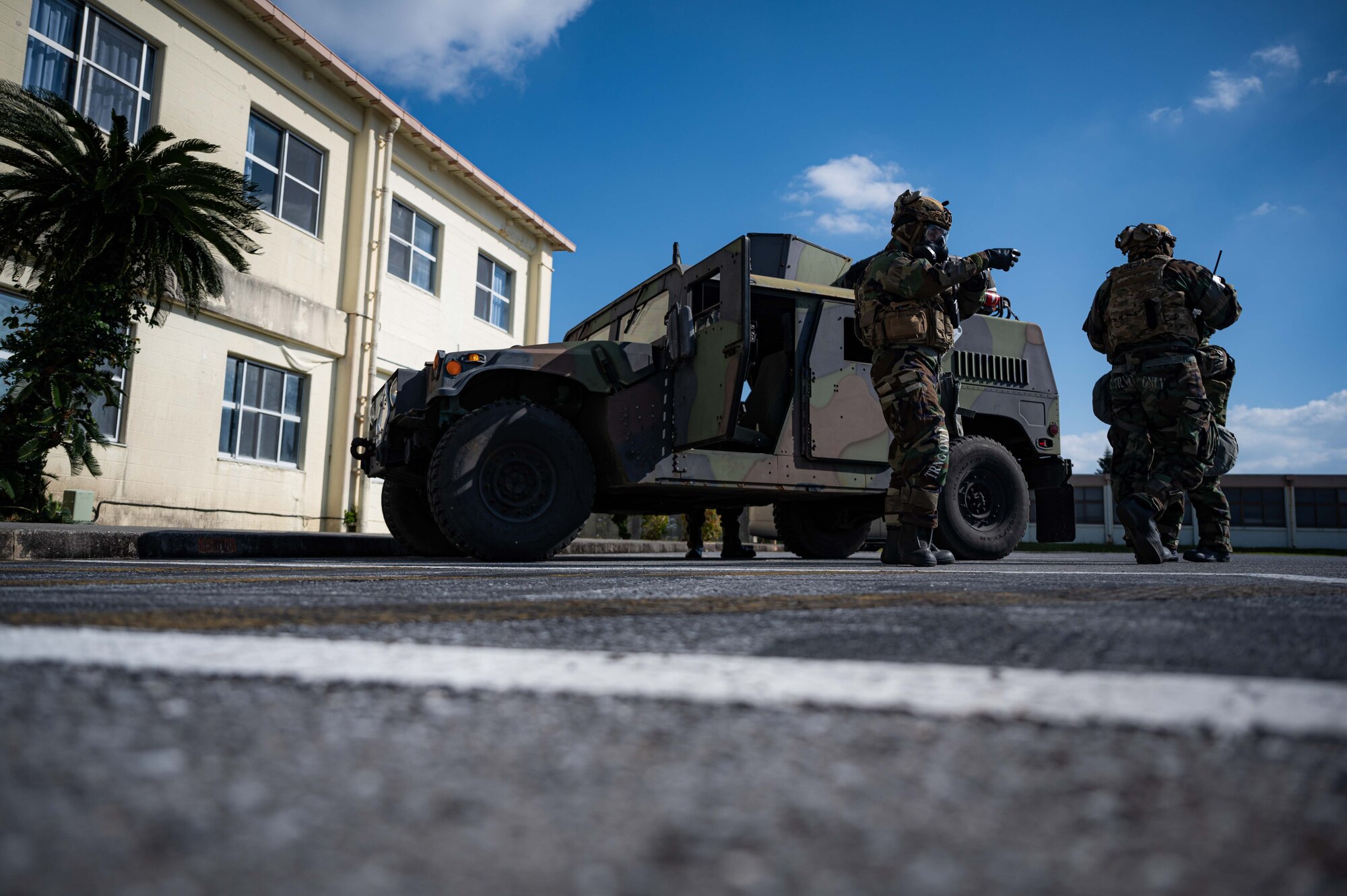 Airmen stand near vehicle.