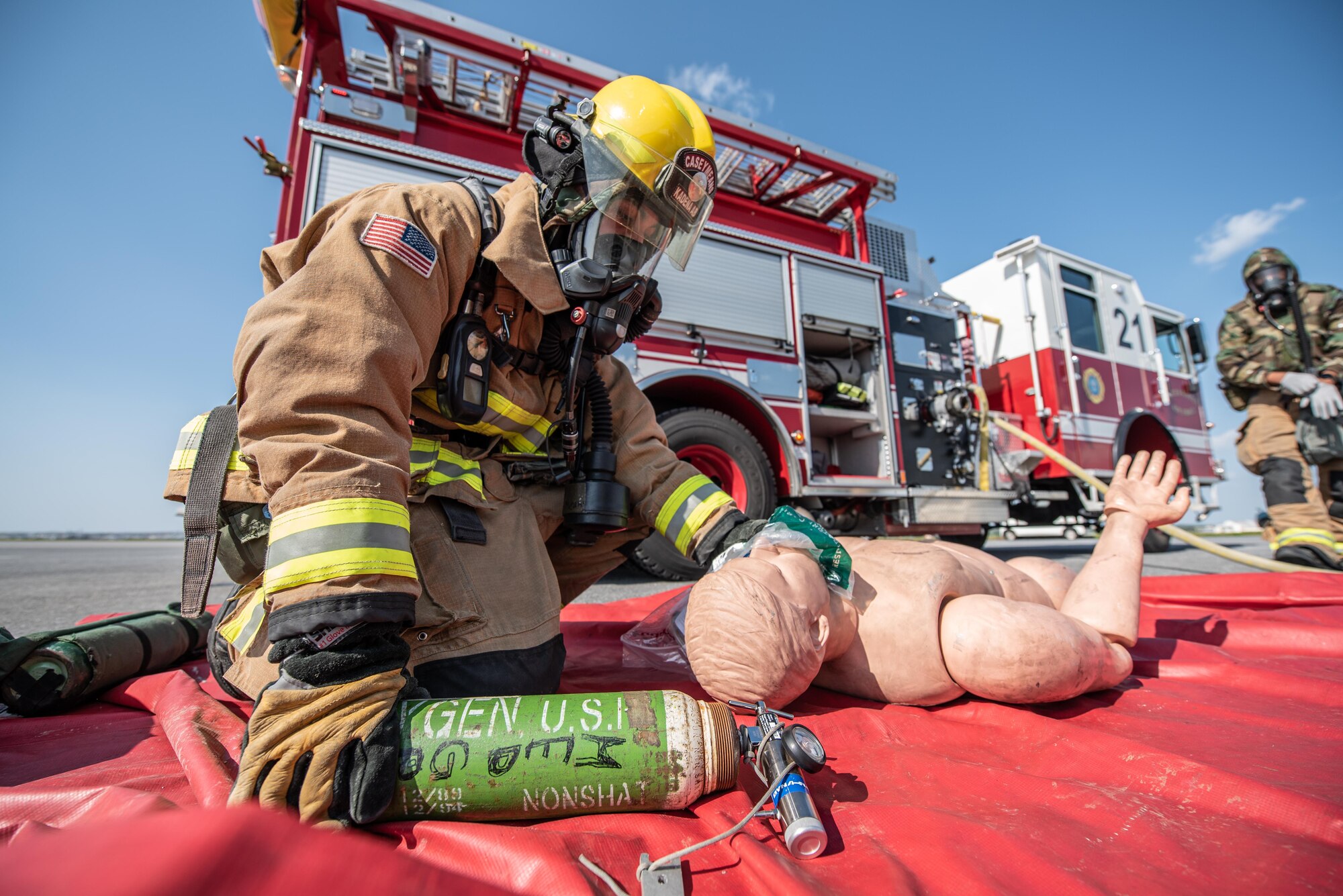 Firefighter gives oxygen to fake patient.