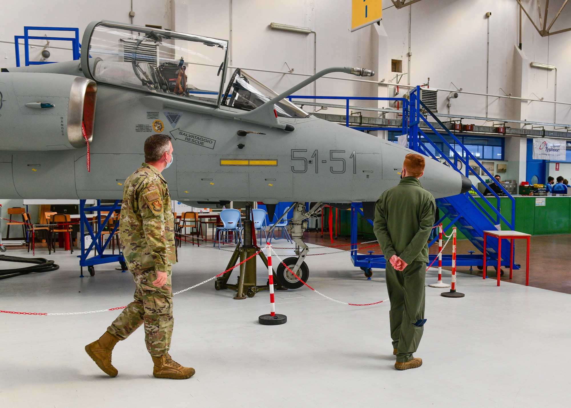 Tech. Sgt. Hunter Newell, 31st Maintenance Group Quality Assurance inspector, left, and U.S. Air Force Capt. Ben Kern, 510th Fighter Squadron F-16 Fighting Falcon pilot, look at an aircraft that’s used for simulations during a visit at the Malignani Aeronautical Institute in Udine, Italy, March 3, 2022. A pilot and maintainer from the 31st Fighter Wing and Col. Marco Schiattoni, Italian base commander, spoke in front of approximately 60 aeronautical high school students and shared their experiences of being in the military. (U.S. Air Force photo by Senior Airman Brooke Moeder)