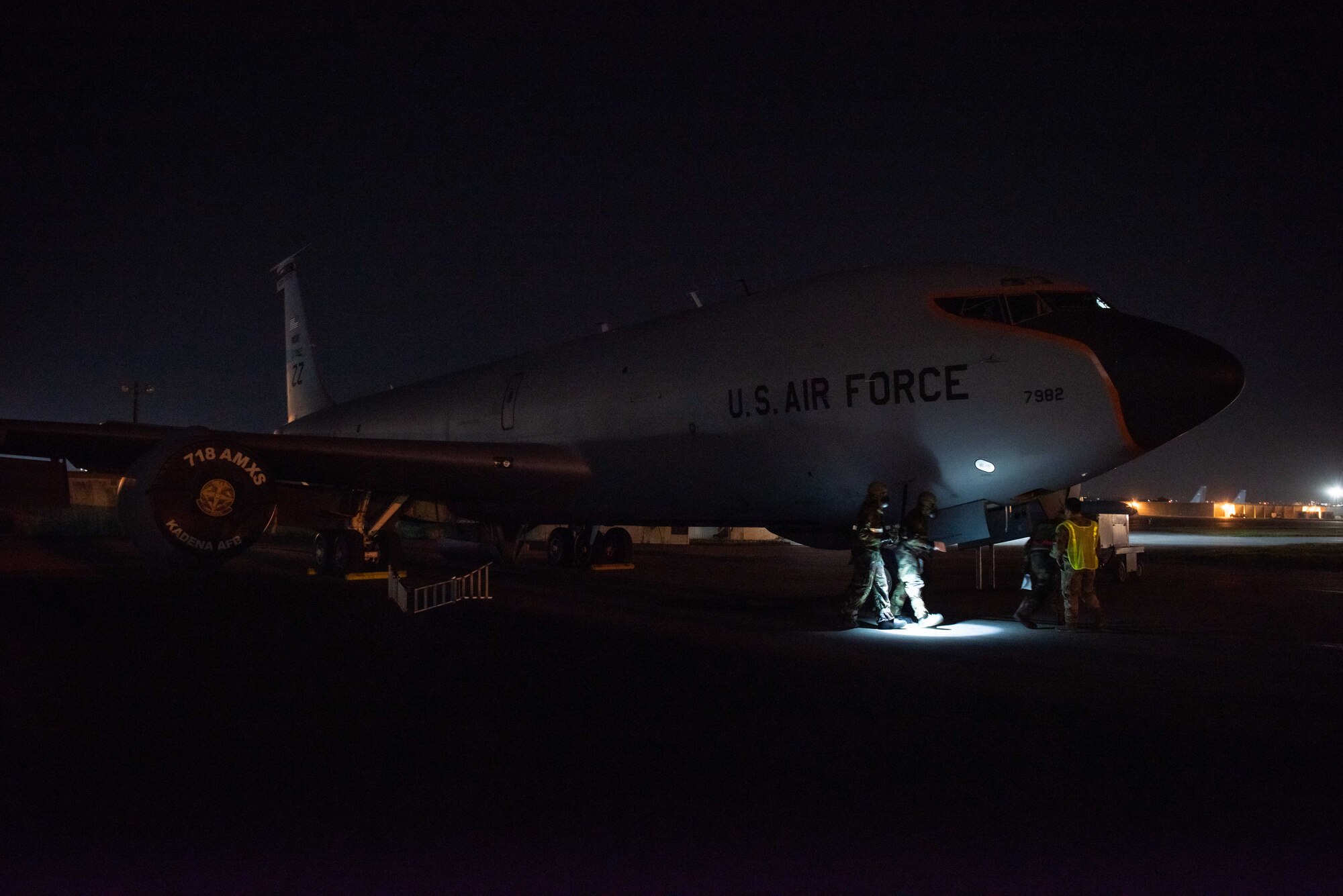 Airmen simulate decontaminating a KC-135 at night.