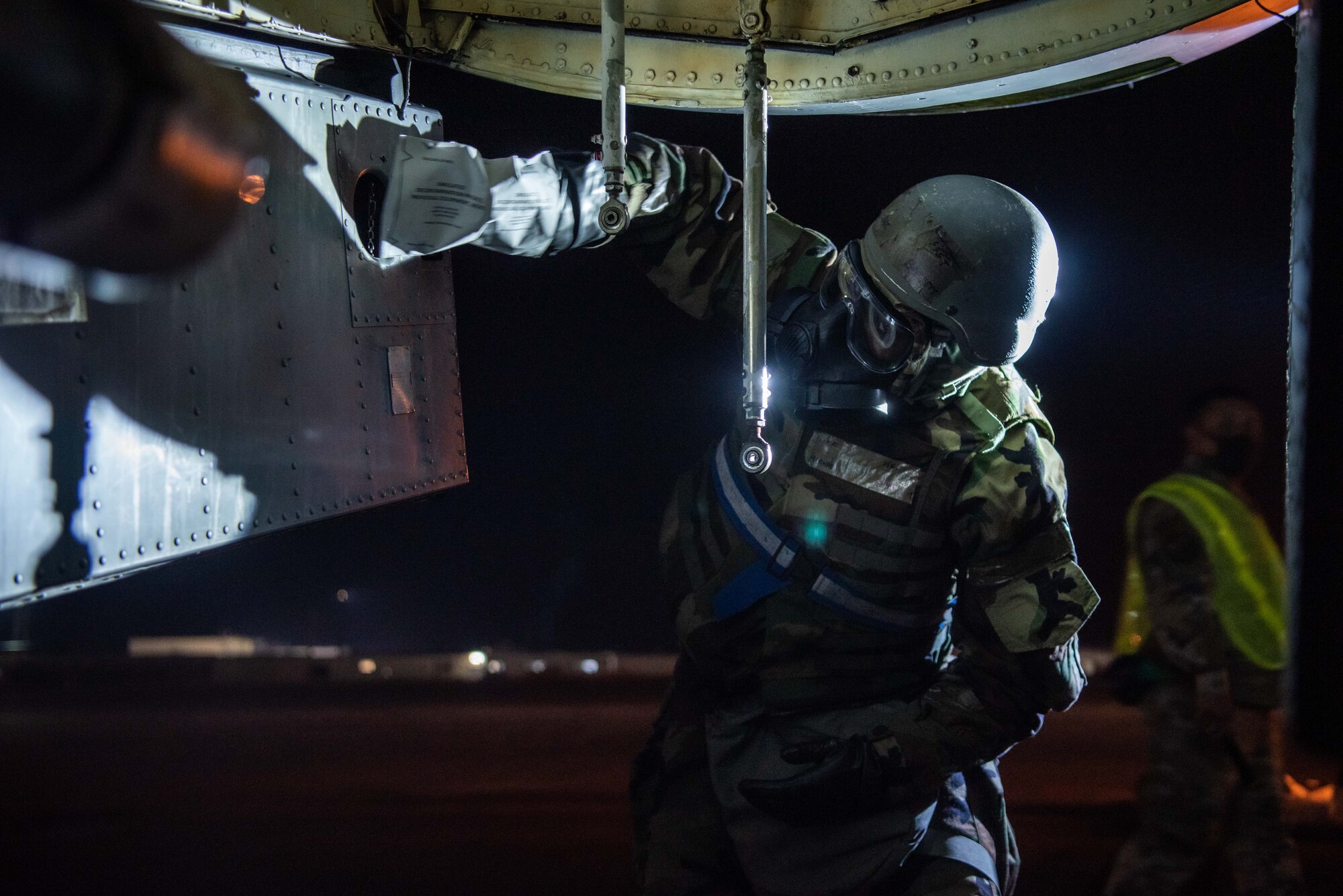 An Airman in protective gear simulates decontaminating a KC-135 Stratotanker.