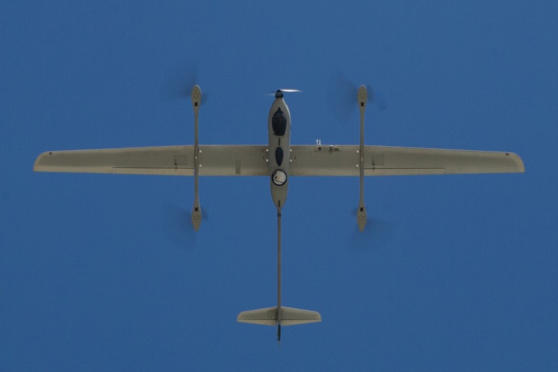 An unmanned aircraft flies across blue sky.