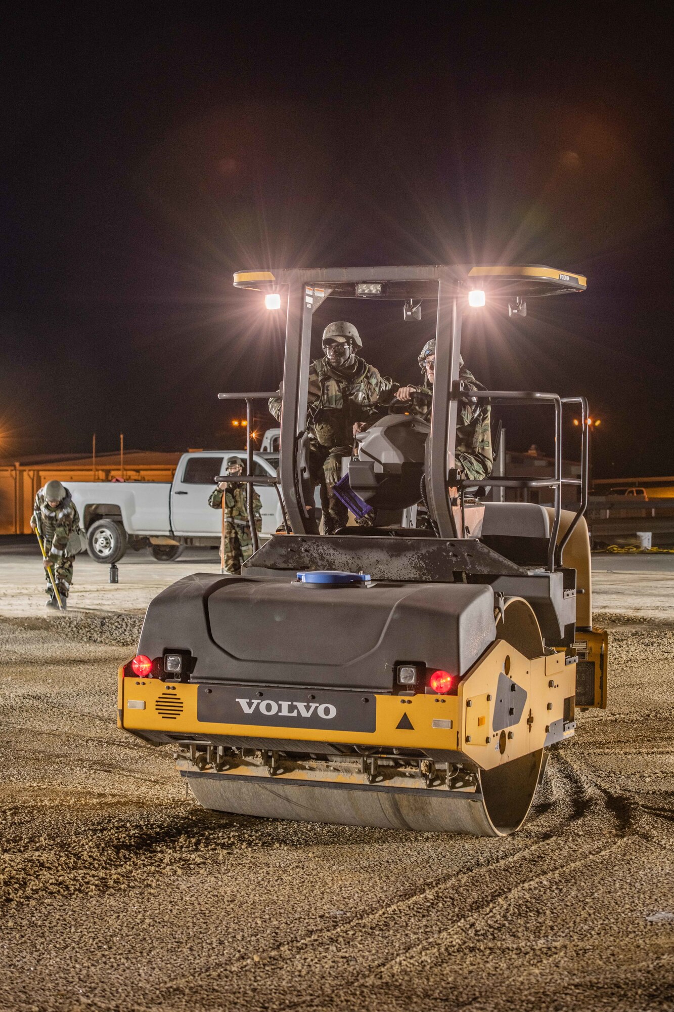 A roller crushes gravel in a hole