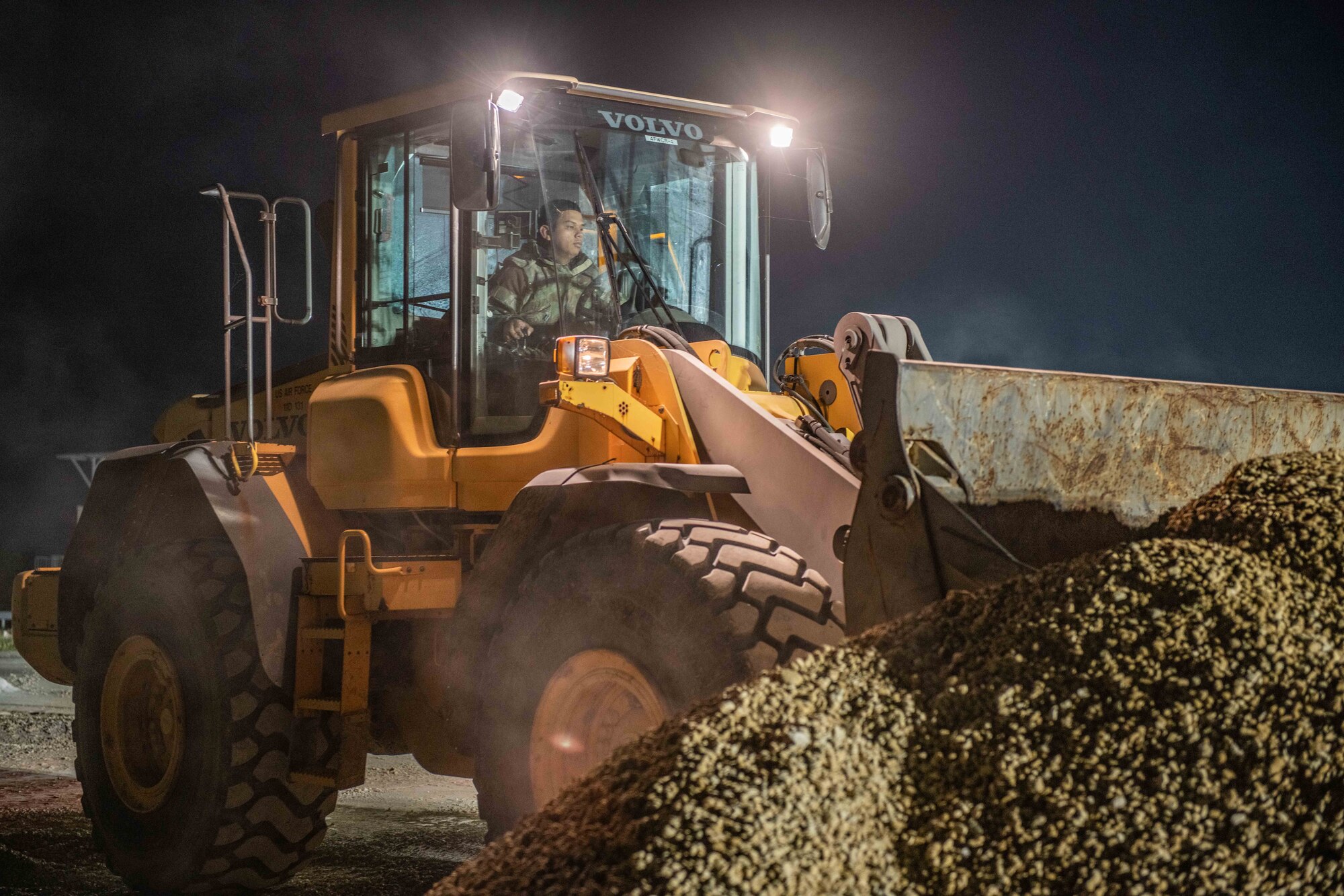 A tractor scoops up a bunch of gravel