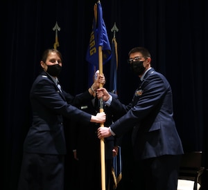 Col. Jennifer L. Mulder, 655th Intelligence, Surveillance and Reconnaissance Group commander, passes the guidon to incoming 14th Intelligence Squadron commander, Lt. Col. Nicholas Herald, during the 14 IS change of command ceremony Feb. 13, 2022.