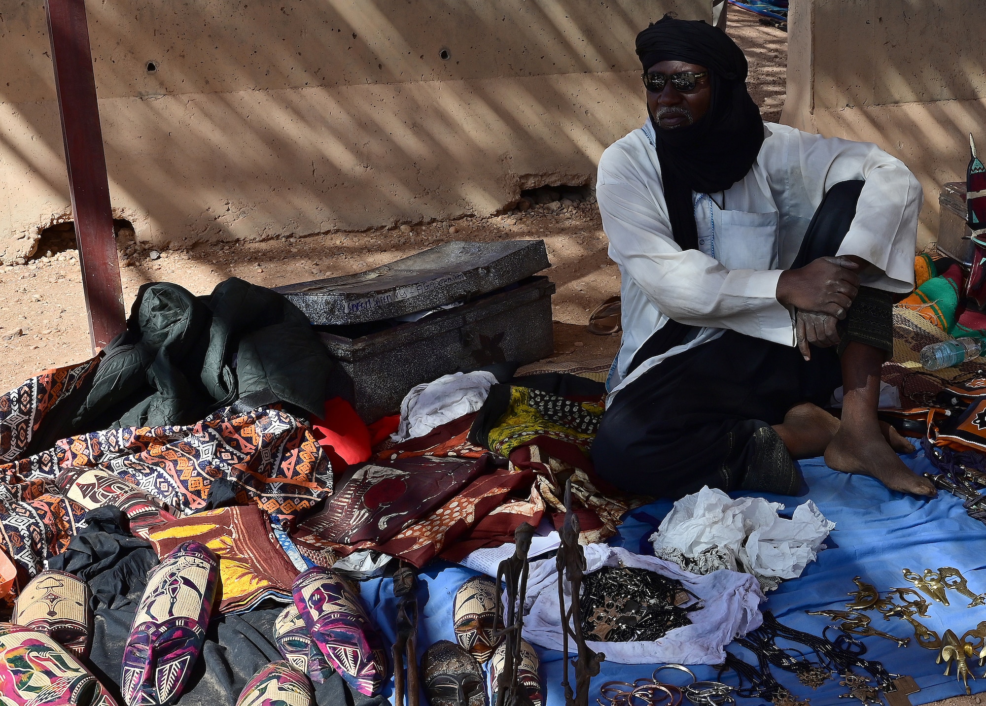 A local vendor displays his goods during a   bazaar at Nigerien Air Base 201, Agadez, Niger, Feb. 27, 2022. Over 40 local vendors from the city of Agadez and surrounding villages attended the bazaar, selling various goods. U.S. service members purchased approximately 10,532,000 West African CFA francs ($18K USD) worth of goods. Events like these enhance U.S., Niger relationships and stimulate local economic development. (U.S. Air Force photo by Tech. Sgt. Stephanie Longoria)