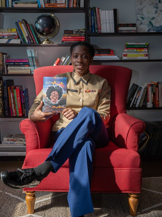 Lance Cpl. Tania R. Bryant, an administration specialist at 6th Marine Corps District, displays her poetry book in the library at 6th MCD, Parris Island, South Carolina, Feb. 25, 2022. Bryant, despite the challenges faced, took her passion of writing and gave it a proper book cover, publishing her first poetry book titled "Poetic Lifelines". (U.S. Marine Corps photo by Lance Cpl. Kevin Lopez Herrera)