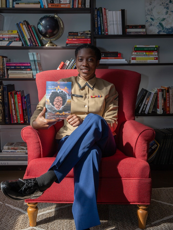 Lance Cpl. Tania R. Bryant, an administration specialist at 6th Marine Corps District, displays her poetry book in the library at 6th MCD, Parris Island, South Carolina, Feb. 25, 2022. Bryant, despite the challenges faced, took her passion of writing and gave it a proper book cover, publishing her first poetry book titled "Poetic Lifelines". (U.S. Marine Corps photo by Lance Cpl. Kevin Lopez Herrera)