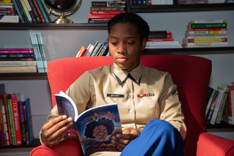 Lance Cpl. Tania R. Bryant, an administration specialist at 6th Marine Corps District, reads her poetry book in the library at 6th MCD, Parris Island, South Carolina, Feb. 25, 2022. Bryant, despite the challenges faced, took her passion of writing and gave it a proper book cover, publishing her first poetry book titled "Poetic Lifelines". (U.S. Marine Corps photo by Lance Cpl. Kevin Lopez Herrera)