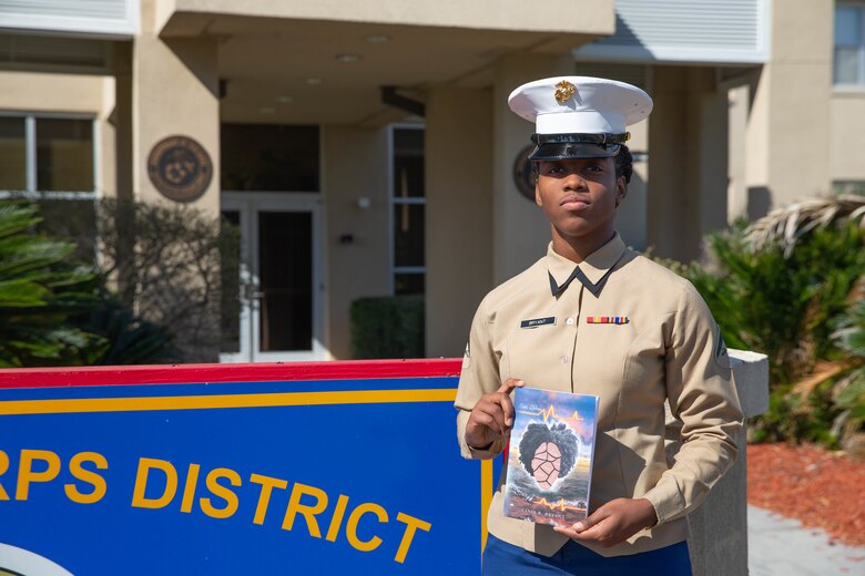 Lance Cpl. Tania R. Bryant, an administration specialist at 6th Marine Corps District, displays her poetry book in front of 6th MCD, Parris Island, South Carolina, Feb. 25, 2022. Bryant, despite the challenges faced, took her passion of writing and gave it a proper book cover, publishing her first poetry book titled "Poetic Lifelines". (U.S. Marine Corps photo by Lance Cpl. Kevin Lopez Herrera)