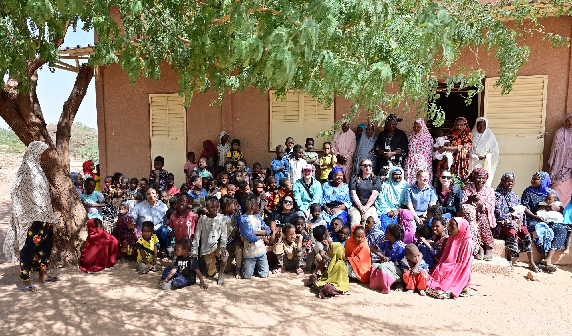 Members from Air Base 201 Women’s Association, Aladab Women’s Association members and children take a group photo in the village of Aladab, Agadez, Niger, Feb 27, 2022. During the visit the 201 Women’s Association engaged with the local community, built relationships, and gained  insight on leadership from a different gender perspective. (U.S. Air Force photo by Tech. Sgt. Stephanie Longoria)