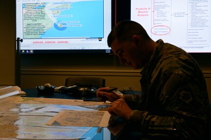 Capt. Brandon Sweeney, current operations officer, Pennsylvania National Guard, marks unit locations on a map of Pennsylvania during a staff training course March 8, 2022. The trial course, hosted by U.S. Northern Command, trained staff on emergency preparedness using a notional Category 2 hurricane scenario.