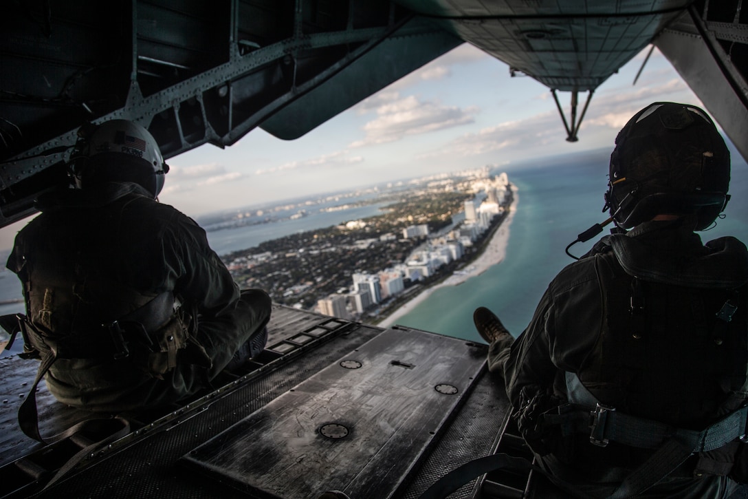 U.S. Marine Corps Capt. Patrick Kelly (left), a CH-53E Super Stallion pilot with Marine Aviation Weapons and Tactics Squadron (MAWTS)-1, and Sgt. Samuel Bonita, a crew chief with Marine Heavy Helicopter Squadron (HMH) 464, look at the skyline over Miami, Florida, Dec. 2, 2021. Marines with HMH-464 trained to increase proficiency in sustained littoral operations from expeditionary advanced bases. HMH-464 is a subordinate unit of 2nd Marine Aircraft Wing, the aviation combat element of II Marine Expeditionary Force. (U.S. Marine Corps photo by Lance Cpl. Christopher Hernandez)