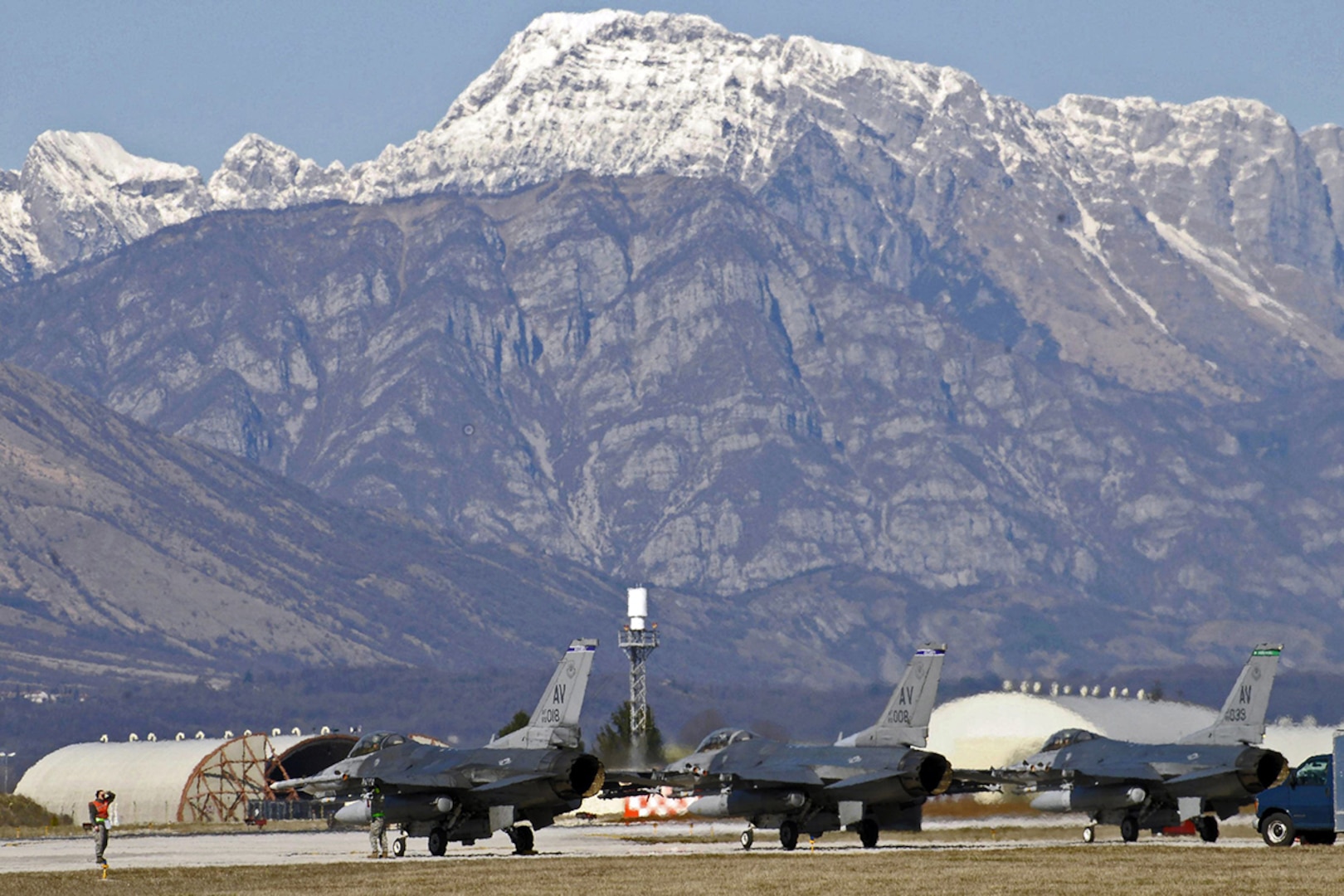 Planes sit on a runway.