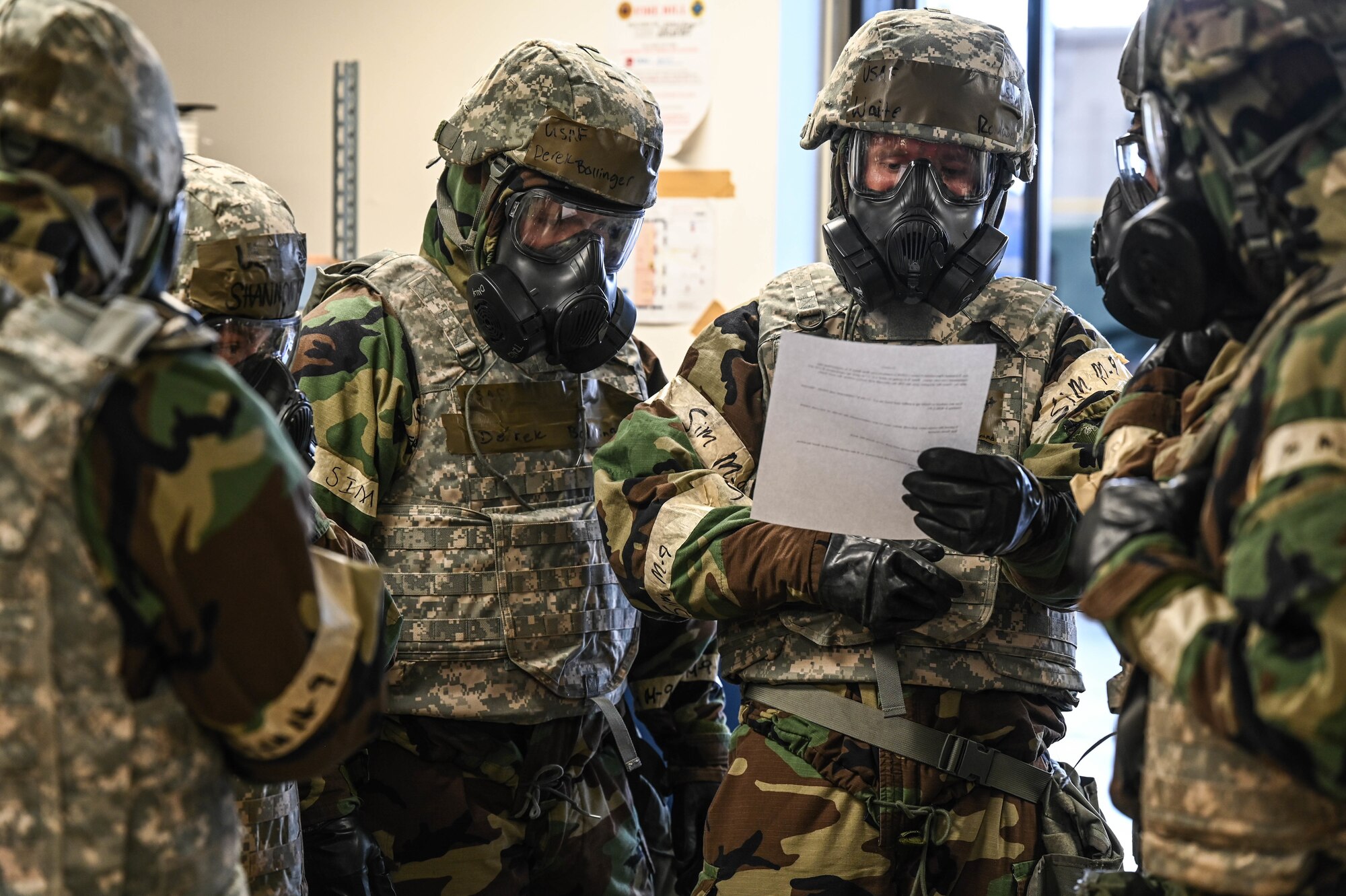 Airmen assigned to the 647th Logistics Readiness Squadron combat mobility flight rally to plan a cargo load during Exercise TROPIC FURY at Joint Base Pearl Harbor-Hickam, Hawaii, March 8, 2022. The six-man team was tasked to palletize, transport and deploy cargo while donned in Mission-Oriented Protective Posture gear. (U.S. Air Force photo by Staff Sgt. Alan Ricker)