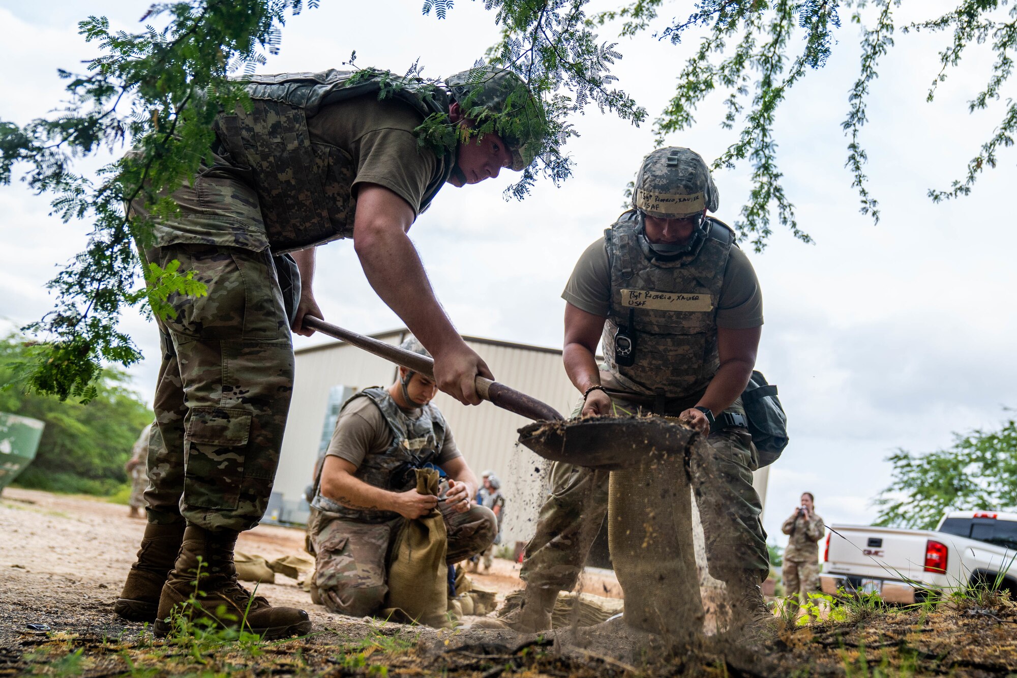 Airmen assigned to the 647th Civil Engineer Squadron fill sandbags to establish an entry control point during Exercise TROPIC FURY at Joint Base Pearl Harbor-Hickam, Hawaii, March 8, 2022. During the exercise, Airmen simulated establishing a forward operating base in a combat environment. (U.S. Air Force photo by Airman 1st Class Makensie Cooper)