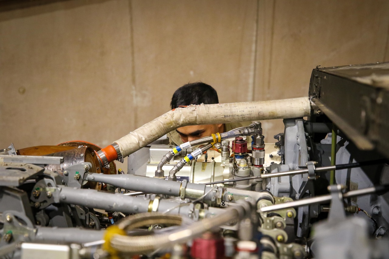 A service member works on an engine.