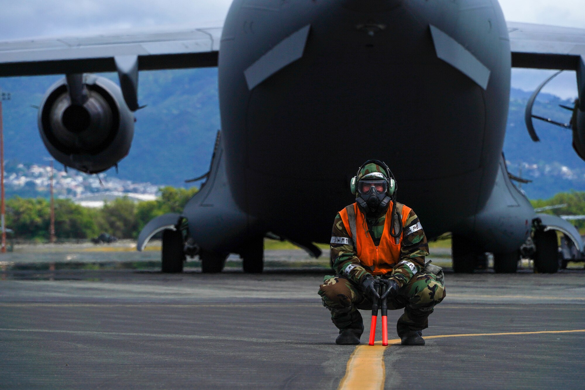 Airman 1st Class William Baldwin, 15th Aircraft Maintenance Squadron crew chief, prepares to marshal in a C-17 Globemaster III after landing at Hickam Airfield at Joint Base Pearl Harbor-Hickam, Hawaii March 8, 2022. After touchdown, aircraft are marshaled to their designated parking spot by crew chiefs. (U.S. Air Force photo by Airman 1st Class Makensie Cooper)