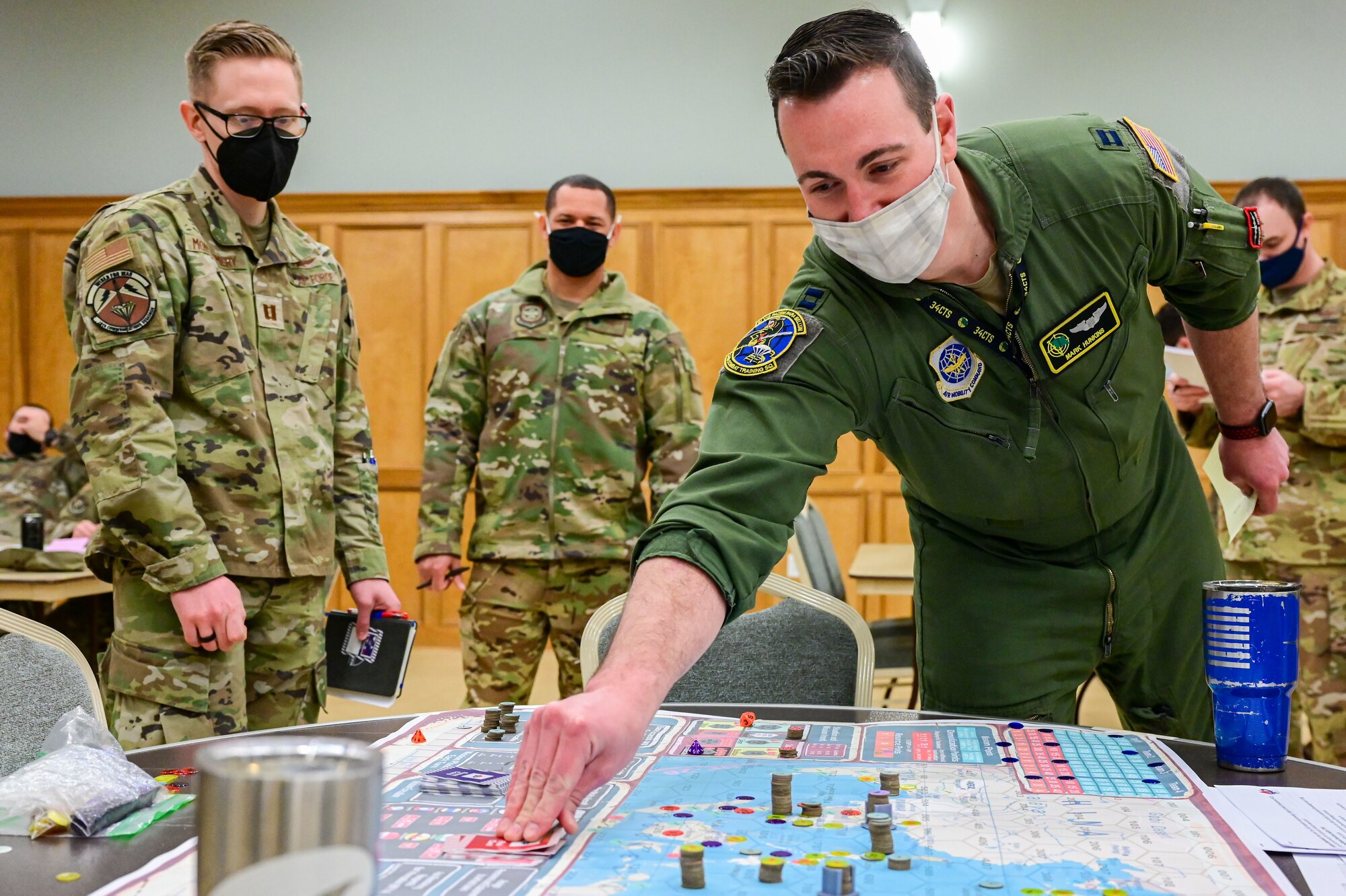 Capt. Mark Hunkins, 34th Combat Training Squadron, picks up a card from the game board during a KingFish Agile Combat Employment exercise