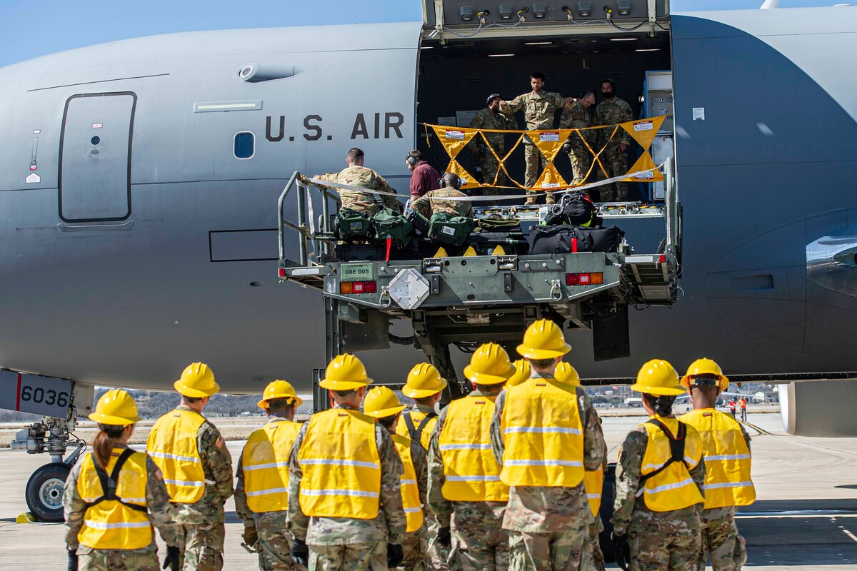Members of Brooke Army Medical Center wait to unload medical equipment and supplies off a KC-46 Pegasus transport aircraft during Ultimate Caduceus 22 Mar 2, 2022 at Kelly Air Field. Ultimate Caduceus is an annual patient movement exercise which assesses the capabilities of and provides field training to aeromedical evacuation teams, critical care air transport teams, medical staging functions and reception and onward movement functions for global patient movement.