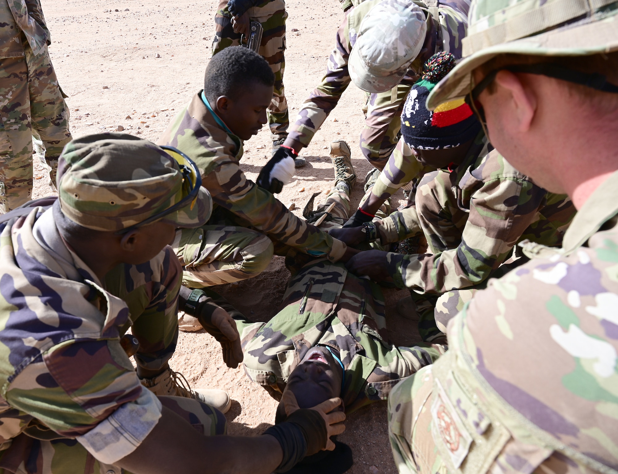 Airman 1st Class Jeremy Witt, 724th Expeditionary Air Base Squadron firefighter, observes Nigerien Armed Forces (French language: Forces Armées Nigeriennes)members perform combat life saving skills during training at Nigerien Air Base 201, Agadez, Niger, Jan. 21, 2022.Training alongside our African partners forges strategic relationships, and builds the operational confidence to cohesively join forces anytime, anywhere. (U.S. Air Force photo by Tech. Sgt. Stephanie Longoria)